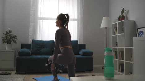 young-woman-with-nice-figure-is-doing-squats-with-dumbbells-at-home-exercises-for-keeping-fit-and-losing-weight-healthy-lifestyle-and-wellness